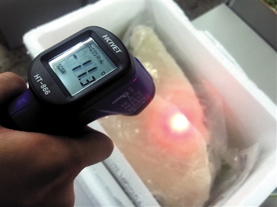 新京报记者用红外测温仪检测生鲜表面温度。新京报记者 林沛青 摄